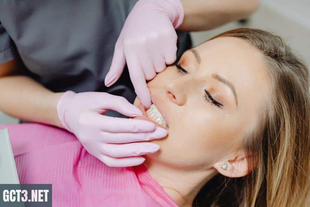A dentist wearing gloves examines a patient's teeth in a close-up view during a dental check-up.